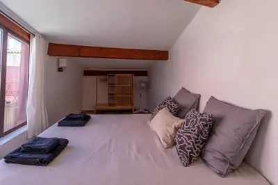 a bedroom with a large bed with pillows on it at Duplex avec terrasse, au cœur d'Aix-en-Provence in Aix-en-Provence