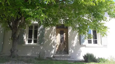 a white house with a door and a tree at Fully renovated Provençal farmhouse in Châteauneuf-de-Gadagne
