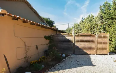a fence in front of a house with a staircase at Maisonnette Avec Jacuzzi in Mazan