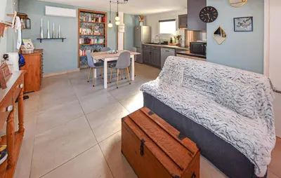 a bedroom with a bed and a kitchen with a table at Maisonnette Avec Jacuzzi in Mazan