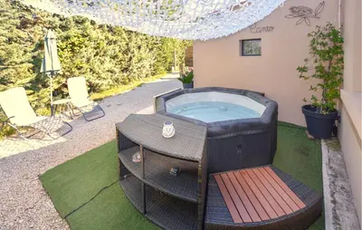 a jacuzzi tub in the backyard of a house at Maisonnette Avec Jacuzzi in Mazan