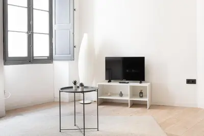 a living room with a tv and a table at Le Rimbaud - Studio moderne en hypercentre - WiFi in Carpentras