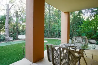a patio with a glass table and chairs on a porch at T2 cosy avec jardin & parking gratuit - Quartier Beauregard in Aix-en-Provence