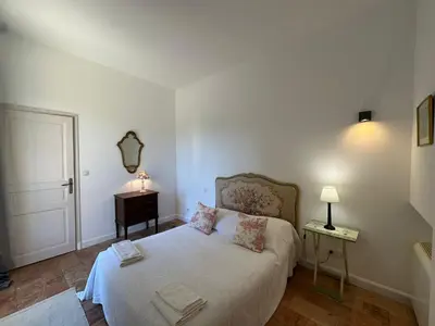 a bedroom with a bed and a table with a mirror at Villa des Cyprès - Charmante maison provençale - Jardin et piscine privés au cœur d un Domaine Viticole Château de Barbebelle Rognes - 10 personnes - Proche d'Aix-en Provence in Rognes