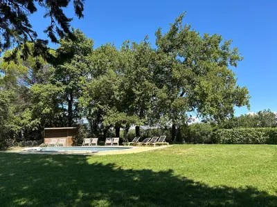 a group of lounge chairs sitting under a tree at Villa des Cyprès - Charmante maison provençale - Jardin et piscine privés au cœur d un Domaine Viticole Château de Barbebelle Rognes - 10 personnes - Proche d'Aix-en Provence in Rognes