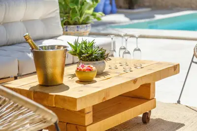 a wooden table with plants on it next to a pool at Charming House At The Foot Of Luberon In Maubec in Maubec