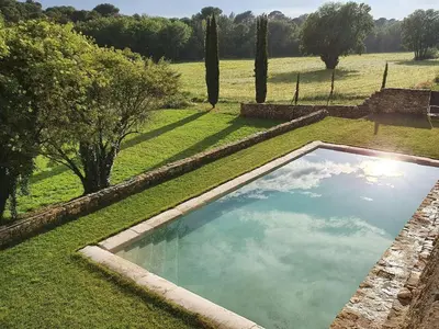 a swimming pool in the middle of a field at Historic Mansion In Provence Vineyards in La Tour-dʼAigues