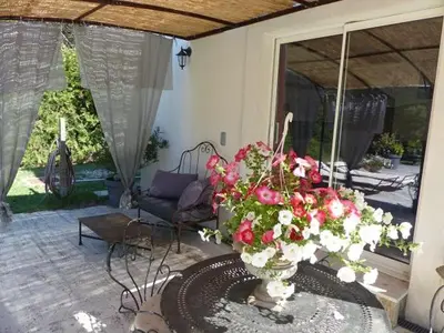 a living room with a vase of flowers on a table at Les Anges in LʼIsle-sur-la-Sorgue