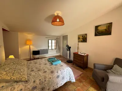 a bedroom with a bed and a couch at Studio Ouest - Chambre avec vue vignoble - Domaine viticole Château Barbebelle Rognes - Proche d'Aix-en-Provence in Rognes