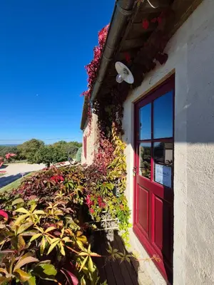 a building with a red door and flowers on it at Studio Ouest - Chambre avec vue vignoble - Domaine viticole Château Barbebelle Rognes - Proche d'Aix-en-Provence in Rognes