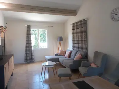 a living room with a couch and a table at Les lauriers in Aubignan
