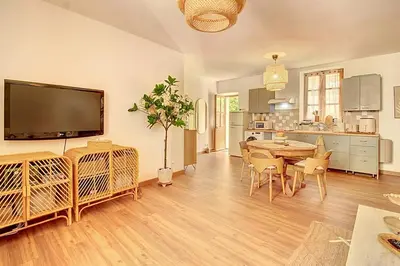 a large living room with a table and a kitchen at La Cour de Pétrarque in Fontaine-de-Vaucluse