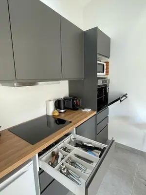 a kitchen with gray cabinets and a counter top at Tiny house avec terrasse privée - Parking - Fibre TV in Lambesc