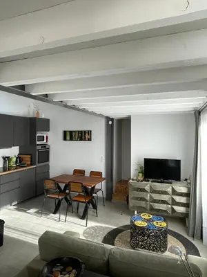 a living room with a table and a kitchen at Tiny house avec terrasse privée - Parking - Fibre TV in Lambesc