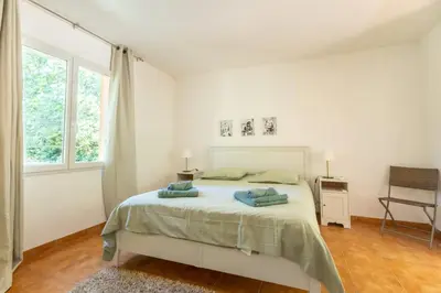 a white bedroom with a bed and a window at Villa sur Domaine Aix - Piscine & Tennis - Wagner in Aix-en-Provence
