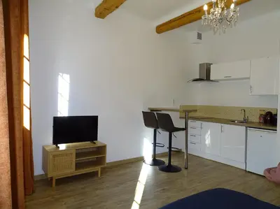 a kitchen with a table and two chairs and a television at AQUA TERRA-Studio Cozy-Aix Historic Center- SMART TV-WIFI in Aix-en-Provence