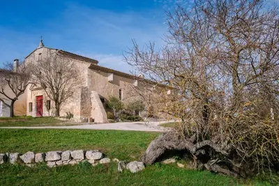 a large brick building with a tree in front of it at Niché au cœur de la Provence - VERNEGUES in Vernègues