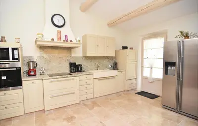 a kitchen with white cabinets and a stainless steel refrigerator at 4 Bedroom Cozy Home In Eygalières in Eygalières