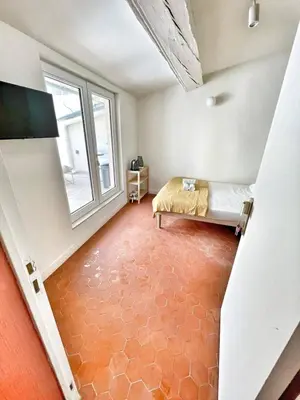 a bedroom with a large bed and a table at Le Mignet by Rentalaix in Aix-en-Provence
