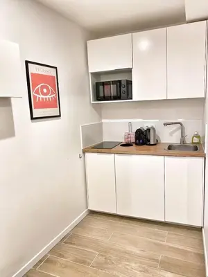 a kitchen with white cabinets and a sink at La Rotonde by Rentalaix in Aix-en-Provence
