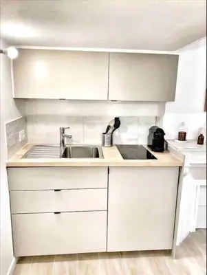 a kitchen with white cabinets and a sink at Le Richelme by Rentalaix in Aix-en-Provence