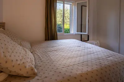 a bed in a bedroom with a window at La Colline - Pause Provençale in LʼIsle-sur-la-Sorgue