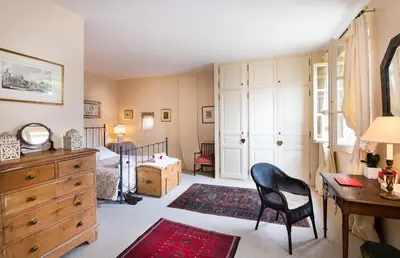 a bedroom with a bed and a desk and a chair at Maison Vignes in Roussillon