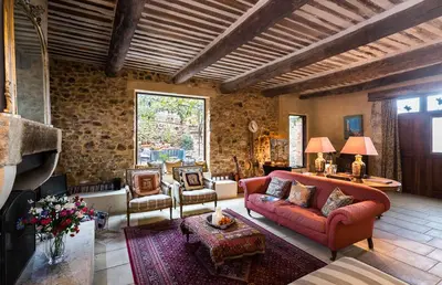 a living room with a red couch and chairs at Maison Vignes in Roussillon