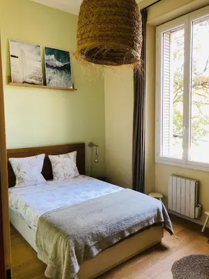 a bedroom with a bed and a large window at Chez Anna - Centre-ville - in LʼIsle-sur-la-Sorgue