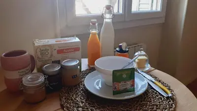 a table with a plate of food and bottles of milk at Chez Anna - Centre-ville - in LʼIsle-sur-la-Sorgue