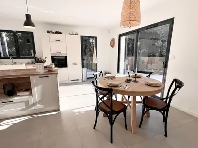 a dining room with a table and chairs in a kitchen at Villa Mimosa in Venasque