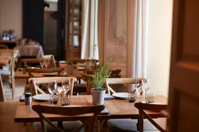 a dining room with wooden tables and chairs with wine glasses at Domaine de Fontenille - Fontenille Collection in Lauris