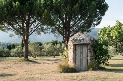 a small stone building with a door in a field at Le cabanon in Vaugines
