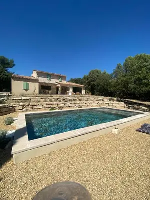 a swimming pool in front of a house at Le bois des chênes in Peypin-dʼAigues