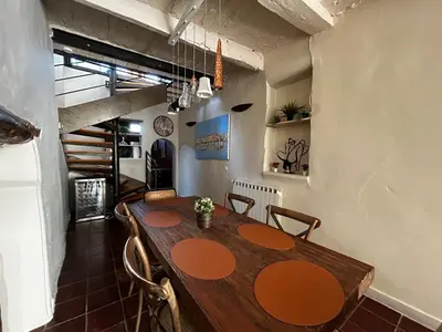 a dining room with a wooden table and chairs at Maison robion in Robion en Luberon