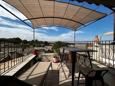 a patio with a table and a view from a balcony at Maison robion in Robion en Luberon