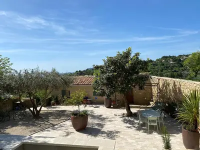a courtyard with a table and chairs and trees at Bastidon, Petite bastide pour 2 avec bassin et jardin privé in Crillon-le-Brave