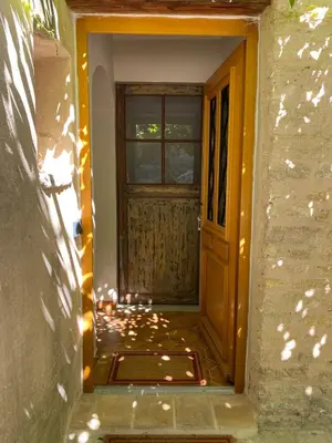 an entrance to a house with a wooden door at Bastidon, Petite bastide pour 2 avec bassin et jardin privé in Crillon-le-Brave
