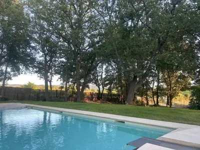 a swimming pool in a yard with trees at Magnifique Mas provencal au coeur des vignes in Mazan