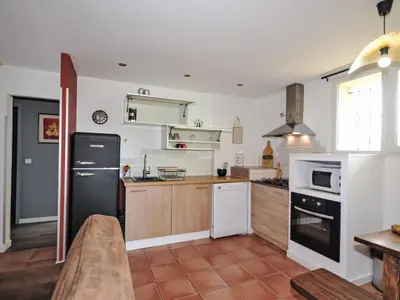 a kitchen with a black refrigerator and wooden cabinets at Apartment Les Santons by Interhome in Peypin-dʼAigues