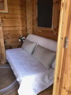 a small bed in a wooden room with a tv at chalet le domaine des cigales in Cavaillon