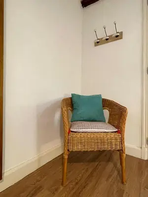 a wicker chair with a green pillow in a room at Charmant Mazet en campagne provencale in Châteaurenard