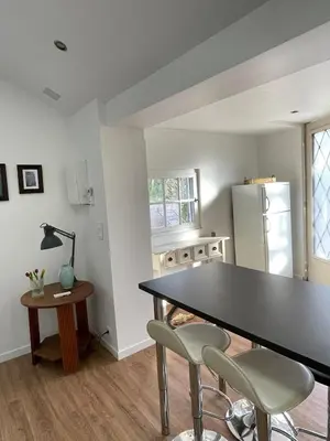 a kitchen with a table and two chairs and a refrigerator at Charmant Mazet en campagne provencale in Châteaurenard