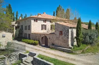 an old stone house with a gate and a driveway at Mas de Thésée Piscine & 12 ha privés in Reillanne