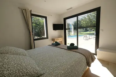 a bedroom with a bed and a large window at Villa with heated pool and Ventoux View in Pernes in Pernes-les-Fontaines