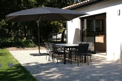 a table and chairs under an umbrella in a yard at Villa with heated pool and Ventoux View in Pernes in Pernes-les-Fontaines