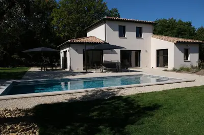 a villa with a swimming pool in front of a house at Villa with heated pool and Ventoux View in Pernes in Pernes-les-Fontaines