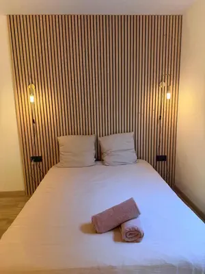 a bedroom with a white bed with two towels on it at Le Clos d'AIX studio 1 in Aix-en-Provence