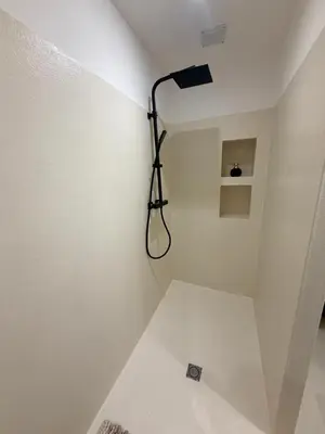 a bathroom with a shower with a light on the wall at Le Clos d'AIX studio 1 in Aix-en-Provence