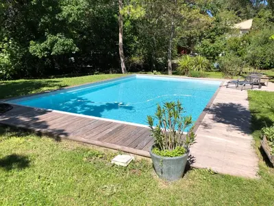 a swimming pool with a wooden deck in a yard at Studio indépendant dans propriété campagne Aixoise terrasse et piscine période estivale in Aix-en-Provence